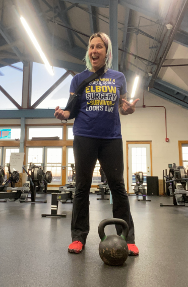 Cindy looks at the camera wearing an elbow surgery survivor t-shirt.