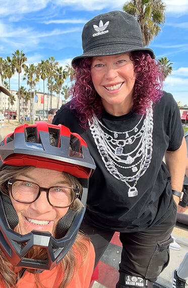 Tracie with a helmet on and Julie beside her. Both are smiling at the camera